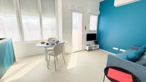 a blue living room with a table and a couch at Studio Ty Lys lumineux, climatisé, balcon, parking gratuit Classé 3 étoiles in Blois