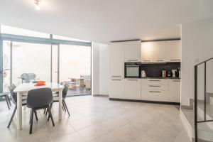 a kitchen with white cabinets and a table with chairs at Secret Garden in Vias
