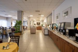 a restaurant with tables and chairs and a cafeteria at Hotel Slavija in Belgrade
