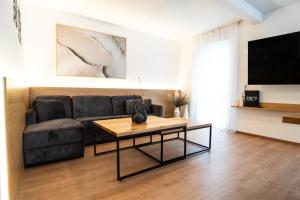 a living room with a black couch and a table at Chalet Maier in Landschach