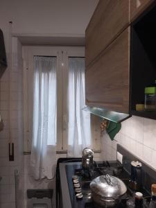 a kitchen with a stove and a window with a pot at Casa Patrizia in Velletri