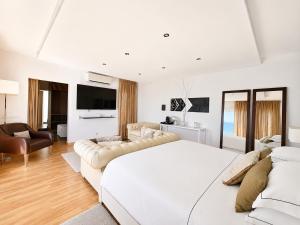 a white bedroom with a large bed and a couch at CASA DO LAGO, Infinity Pool, Mountains & Sea view in Estói +77 photos