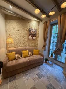 a living room with a brown couch and yellow pillows at Gambetta in Arles