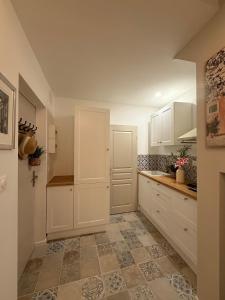 a kitchen with white cabinets and a tile floor at Gambetta in Arles