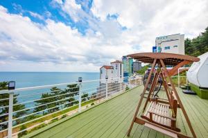 a wooden deck with a bench and the ocean at Samcheok eastocean in Samcheok