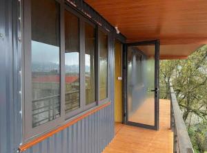 an open glass door on a house with a balcony at Hostel 405 Sa Pa in Sapa