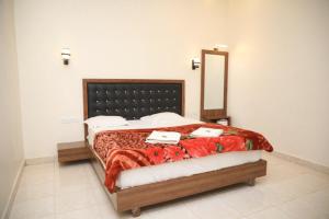 a bedroom with a large bed with a mirror at New Krishna Hotel Matheran in Matheran