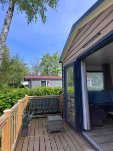 a wooden deck with a sliding glass door at Chalet Pampusplaat 16 in Lauwersoog