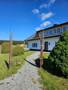 a house with two wooden posts in front of it at Böhmerwald fun in Schwarzenberg am Bohmerwald