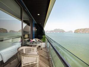 a balcony with a table and chairs on a boat at Cruise Lan Ha Bay 2 Day 1 Night pick-up from Cat Ba Central in Cat Ba