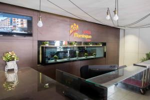 Mornington Hotel Waterfront Lumut في لوموت: مطعم بطاولة وعلامة على الحائط
