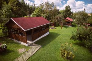 a smallshed with a red roof in a garden at Flóra Apartmanok in Parádsasvár