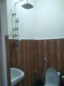 a bathroom with a shower with a toilet and a sink at Zenaria in Liquica