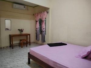 a bedroom with a bed and a table and a desk at Zenaria in Liquica