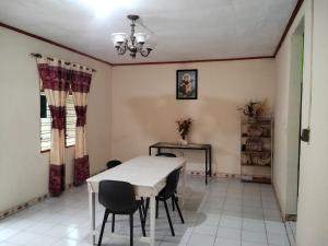 a dining room with a white table and chairs at Zenaria in Liquica