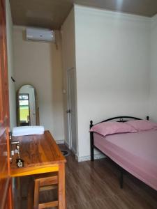 a bedroom with a bed and a table and a mirror at Zenaria in Liquica