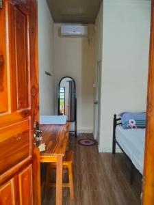 a room with a wooden table and a mirror at Zenaria in Liquica