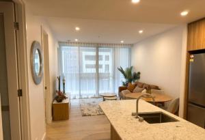 a living room with a kitchen and a living room with a couch at 2BR Elevated Living Suite in Campbell