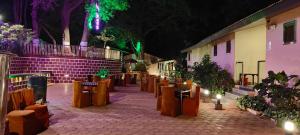 a row of tables and chairs in a courtyard at night at New Krishna Hotel Matheran in Matheran