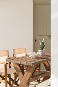 a wooden dining table with chairs and a plant on it at Blu Dot Tinos in Dhió Kkhoriá +31 photos