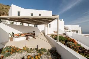 a white house with a patio with flowers at Blu Dot Tinos in Dhió Kkhoriá