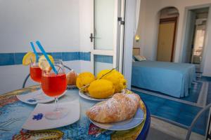 a table with two plates of bread and two drinks at Meublè Casa Mannini Rooms in Maiori +55 photos