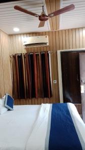 a bedroom with a bed and a ceiling fan at hotel sooryoday j in Varanasi +4 photos