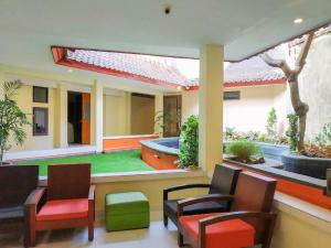 a patio with chairs and a pool in a house at Guntur Hotel Bali in Ketewel