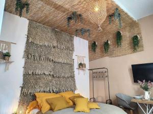 a bedroom with a wall with a bed with yellow pillows at Cloître in Arles