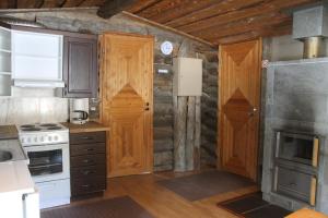 a kitchen with wooden cabinets and a stove top oven at River Cabin Urpo in Inari