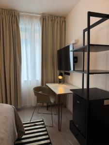 a bedroom with a desk and a bed and a window at MY STAY - Smart Hotel in Mönchengladbach