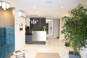 an office lobby with plants and a reception desk at Hotel Crystal in Hajdúszoboszló