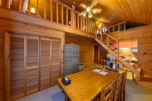 ein Esszimmer mit einem Holztisch und einer Treppe in der Unterkunft Madarao Vacances Village in Iiyama