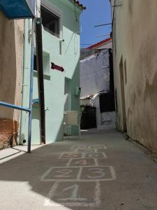an alley with a chair in a building at Little Kristi in Palaiókastron