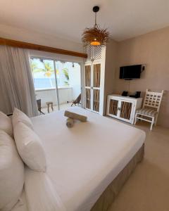 a bedroom with a large white bed with a view of the ocean at VR CLUB Tulum Riviera in Tulum