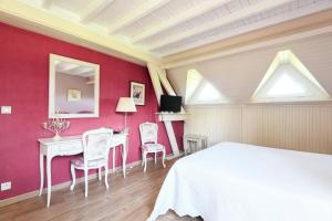 a bedroom with a white bed and a table and chairs at La Bulle in Verton