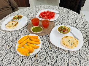 a table with plates of food and drinks on it at Amrit bela in Haridwār
