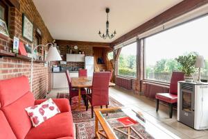 a living room with a red couch and a table at La Bulle in Verton
