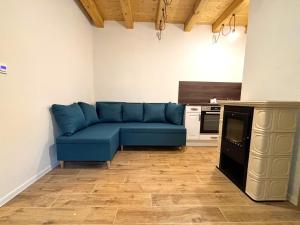 a living room with a blue couch in a kitchen at Chalupa Renatka in Hartvíkovice