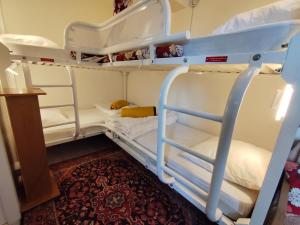 a bunk bed with white bunk beds in a room at La Tanière in Ustou
