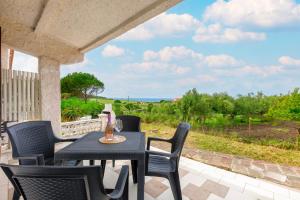 a table and chairs on a patio with a view of the ocean at Villa Rosa Sea View in Valledoria