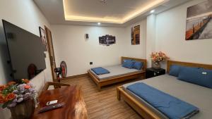 a room with two beds and a table in it at Nắng Hotel in Cẩm Mỹ