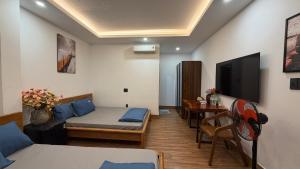 a small room with a bed and a television at Nắng Hotel in Cẩm Mỹ