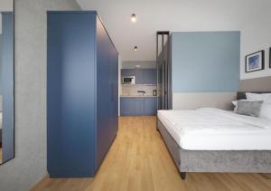 a bedroom with a bed with a blue wall at Brera Serviced Apartments Singen in Singen