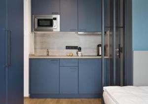 a blue kitchen with a sink and a microwave at Brera Serviced Apartments Singen in Singen
