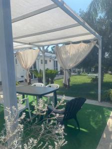 a picnic table and chairs under a white canopy at GMD Sweet Home in Policoro