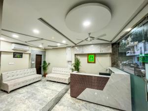 a lobby with a waiting room with white chairs and a reception desk at Hotel Prime Access Inn in Indore