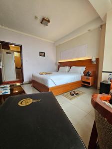 a hotel room with a large bed and a desk at C Fun Addis Hotel in Addis Ababa