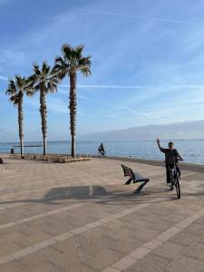 a person riding a bike next to the beach at BluehousePortixol Mallorca in Palma de Mallorca