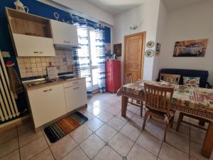 a kitchen and dining room with a table and a refrigerator at La Dimora di Helios in Noto